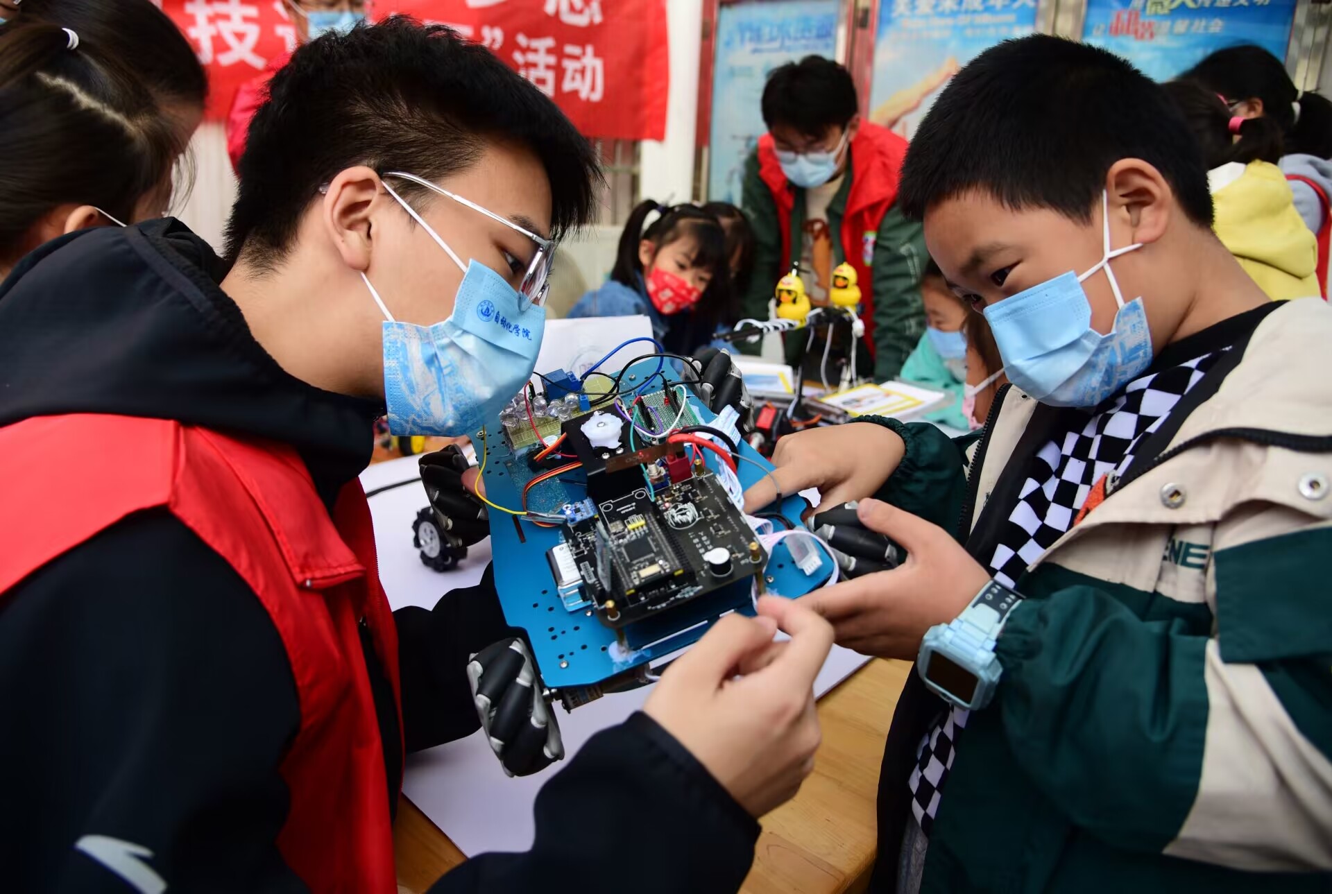 1668221713202419.jpg 图4 志愿者向小朋友们展示智能车.jpg