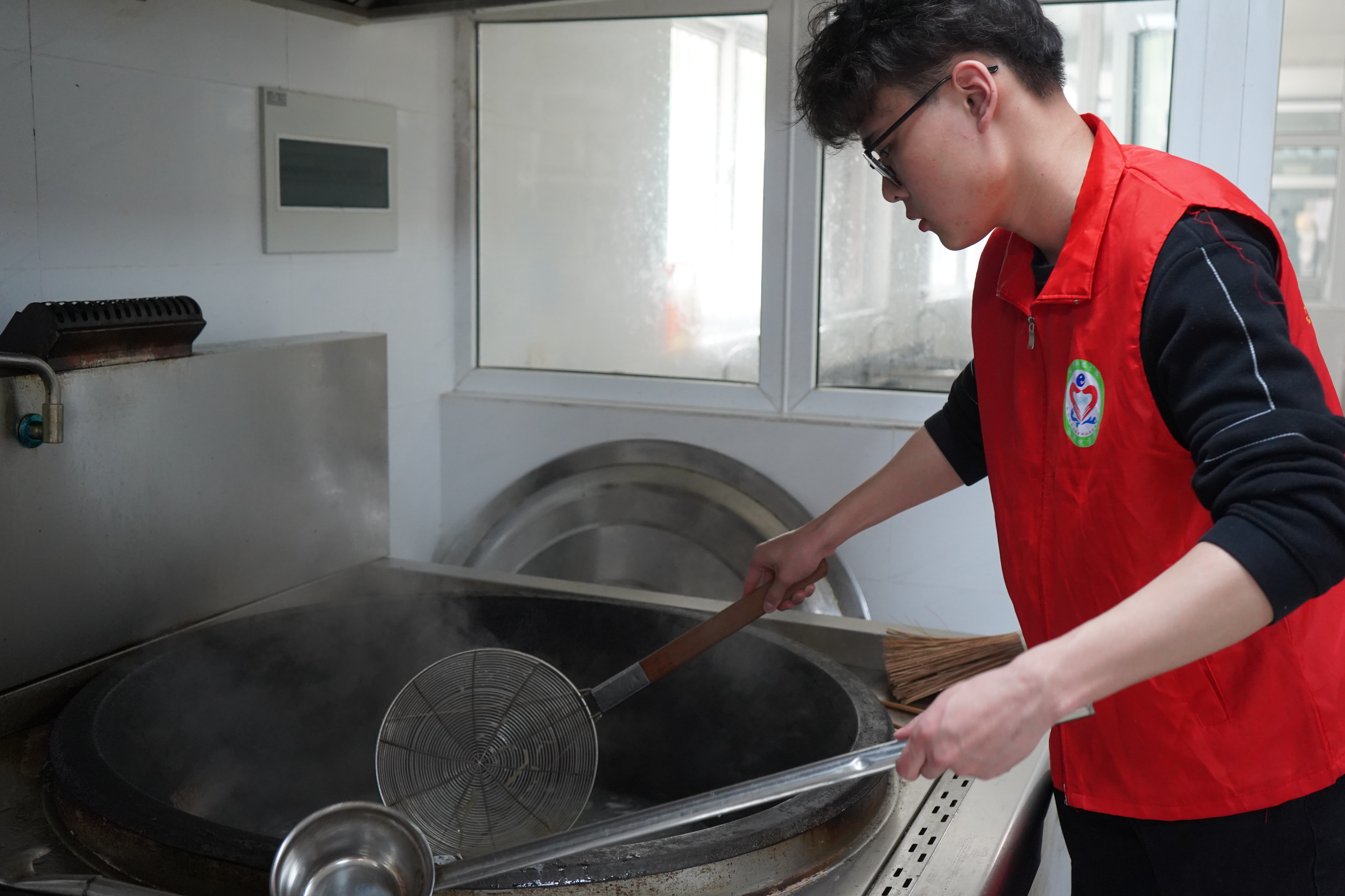 1682688064533886.jpg 图为必赢bwin官网登录入口自动化学院志愿者樊子轩为镇江市润商小学一年级一班同学准备材料,煮开面条.JPG